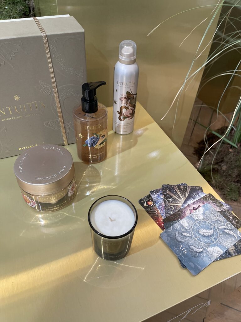 productos de la colección Intuitia de Rituals para el cuerpo junto a la vela